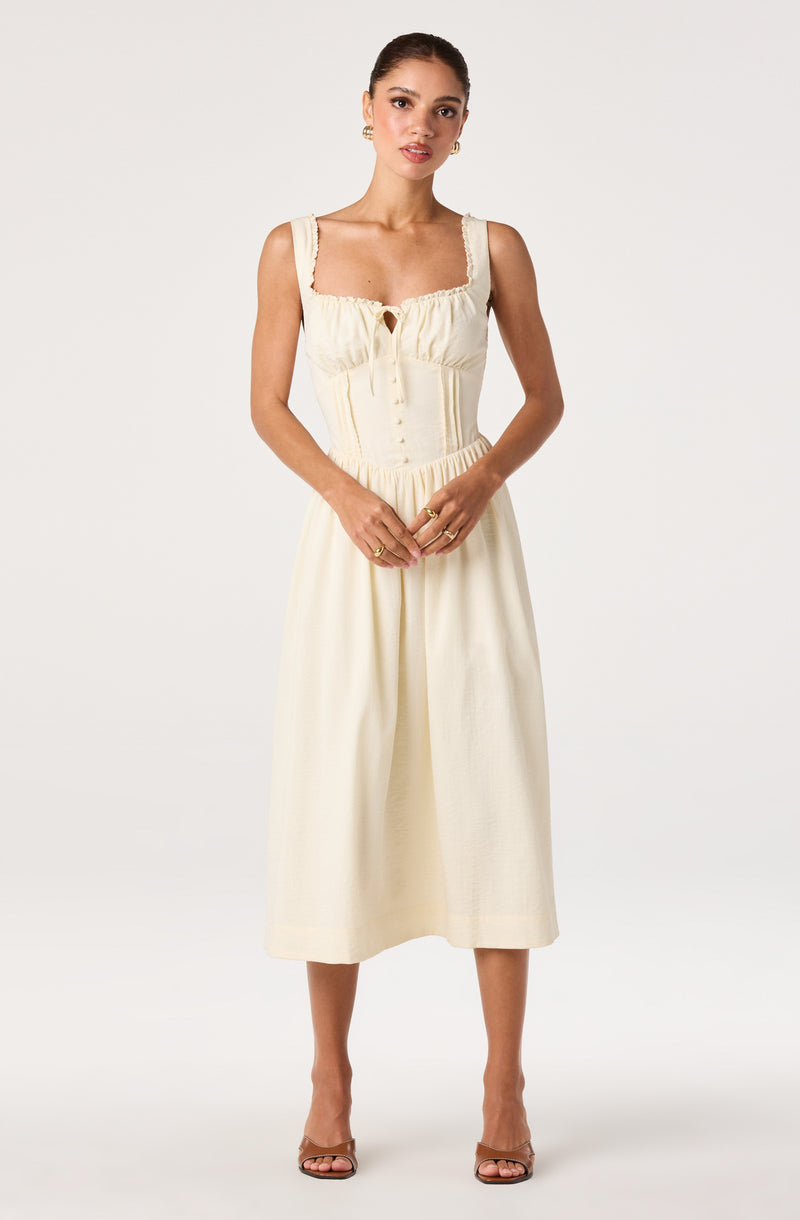 Cream sleeveless dress with lace details, button-up front, and a gathered waist.