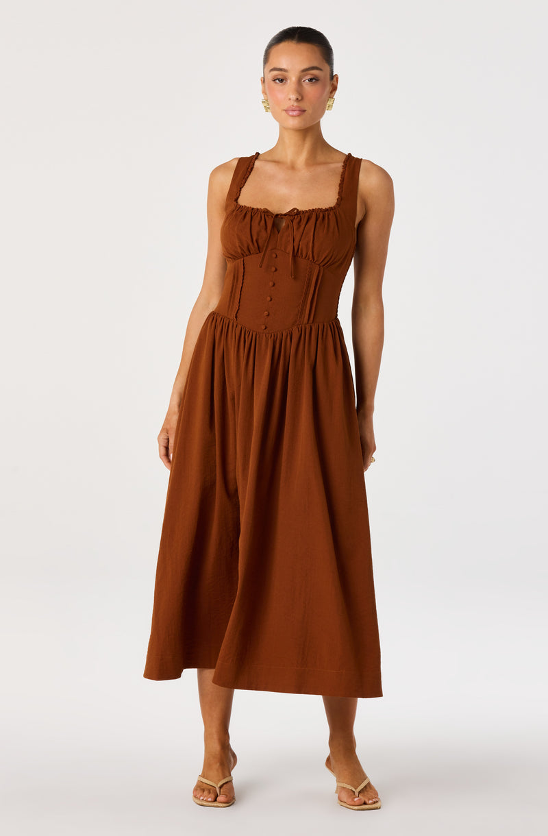 Brown sleeveless dress with gathered details, fitted bodice with buttons, and a full, wide skirt.