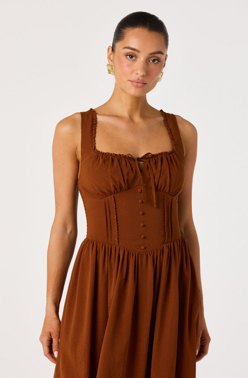 Brown sleeveless dress with ruffled neckline and fitted waist.