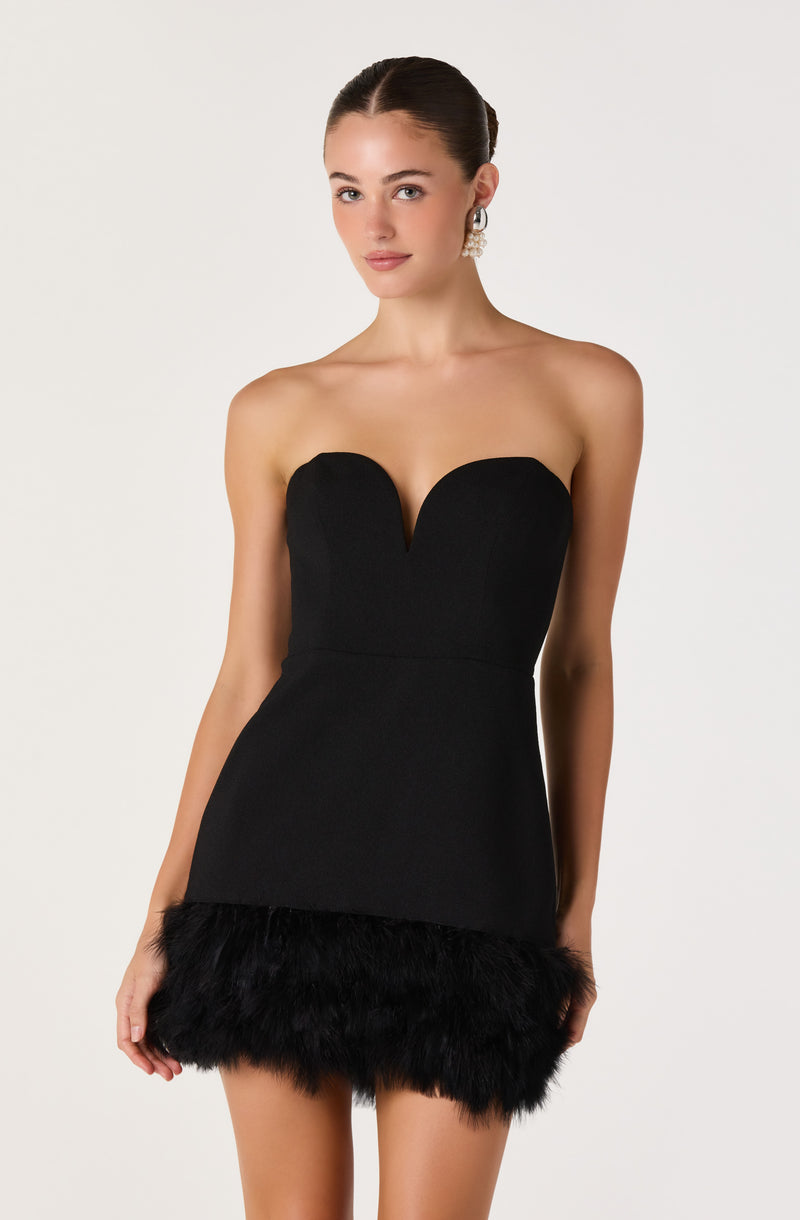 Woman in a strapless black dress with feathered hemline.