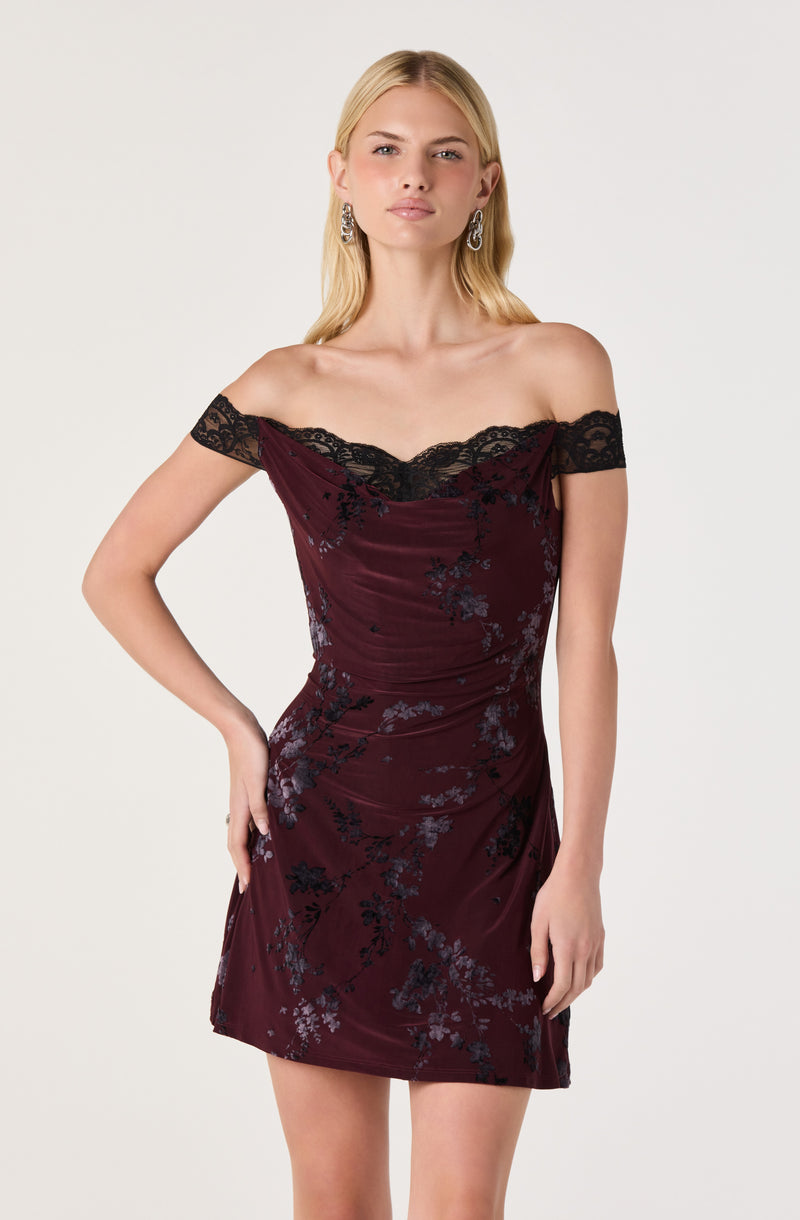 Off-shoulder burgundy dress with black floral pattern and lace trim at the neckline.