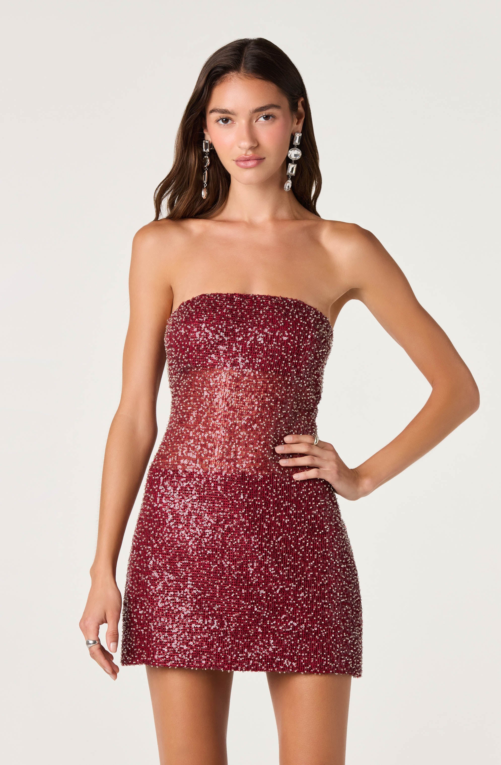 Woman wearing a strapless, red, sequined, fitted mini dress.