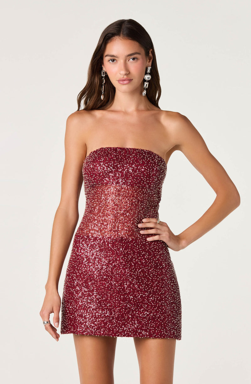 Woman wearing a strapless, red, sequined, fitted mini dress.
