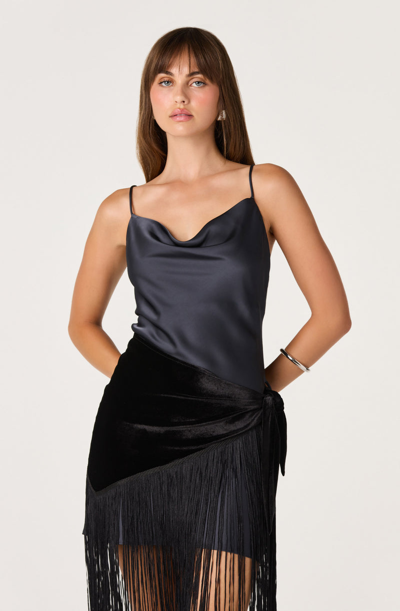 Black satin camisole top with spaghetti straps and a velvet and fringe skirt.