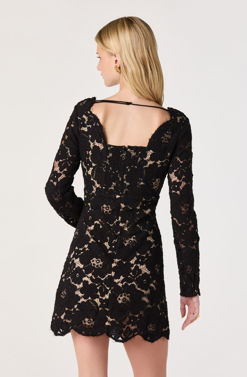 Black lace dress with long sleeves and a square neckline, layered over a nude slip.