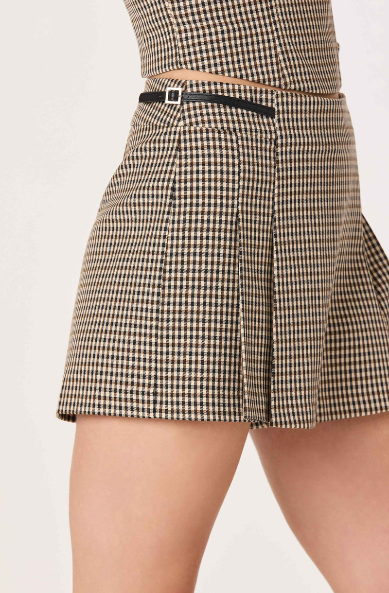 Close-up of plaid shorts with black trim and belt detail.