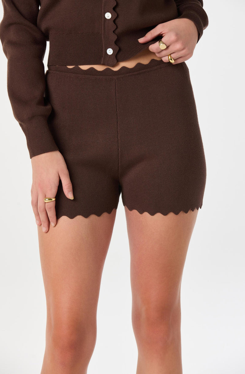 Brown matching knit cardigan and shorts with scalloped edges.