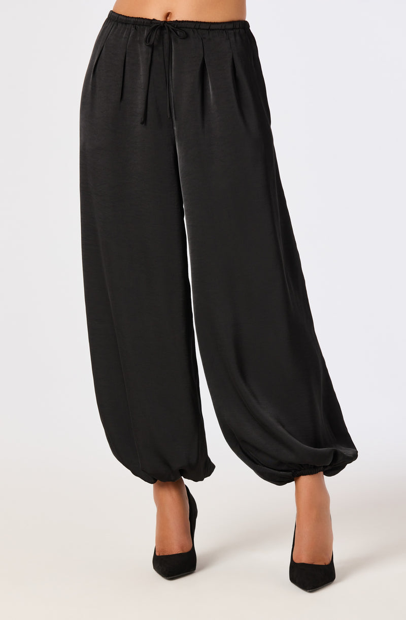 Black satin wide-leg pants with an elastic waistband and drawstring, gathered at the ankles.