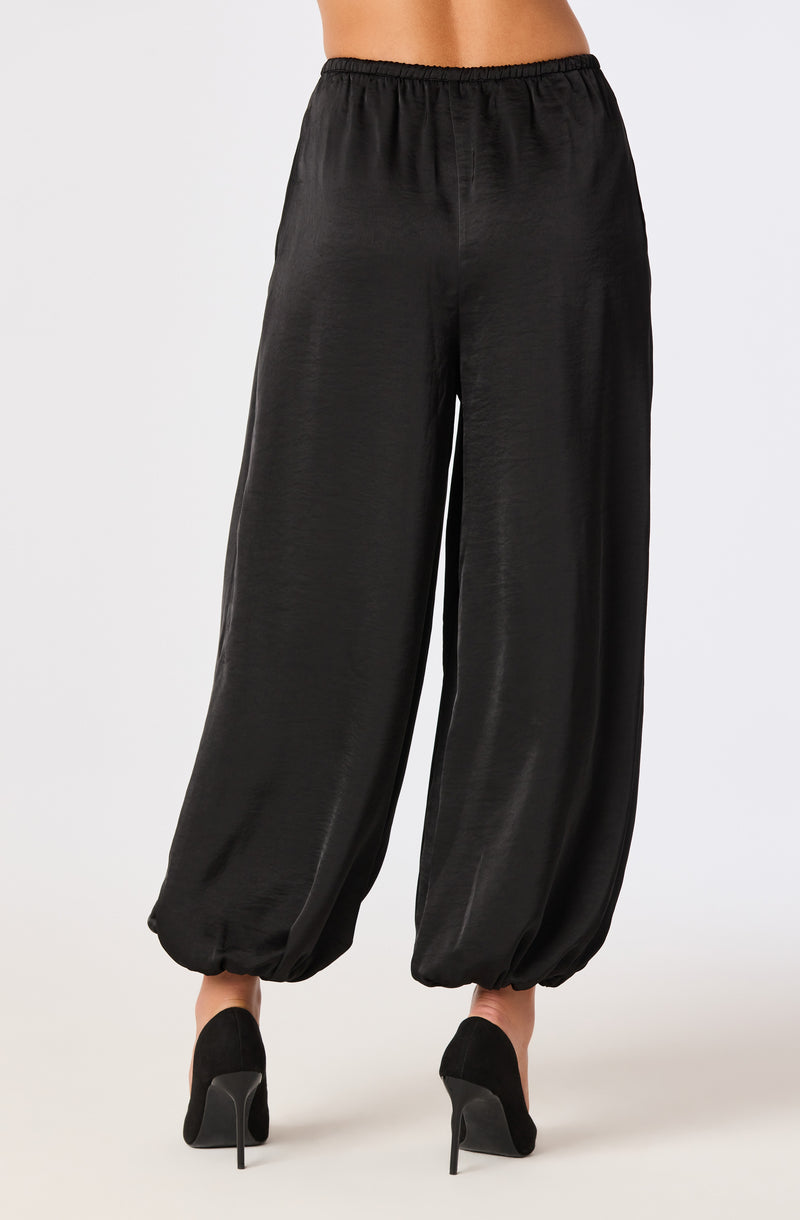 Black satin wide-leg pants with elastic waistband and gathered ankle cuffs.