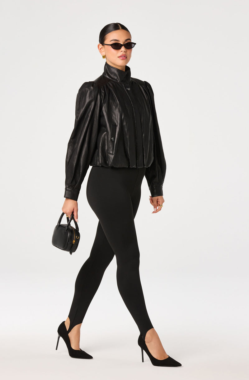 Woman wearing a black leather jacket, black leggings, and black high heels.