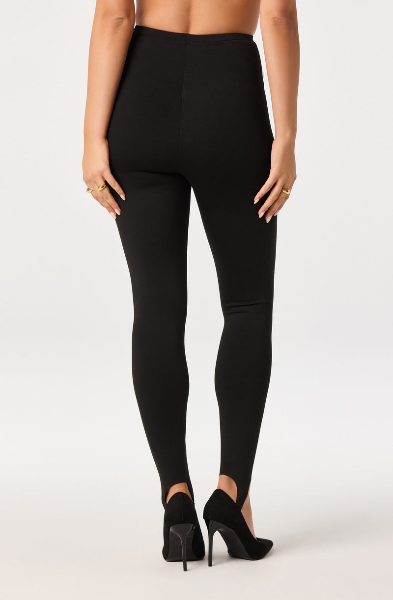 High-waisted black leggings with a smooth finish, paired with black high heels.