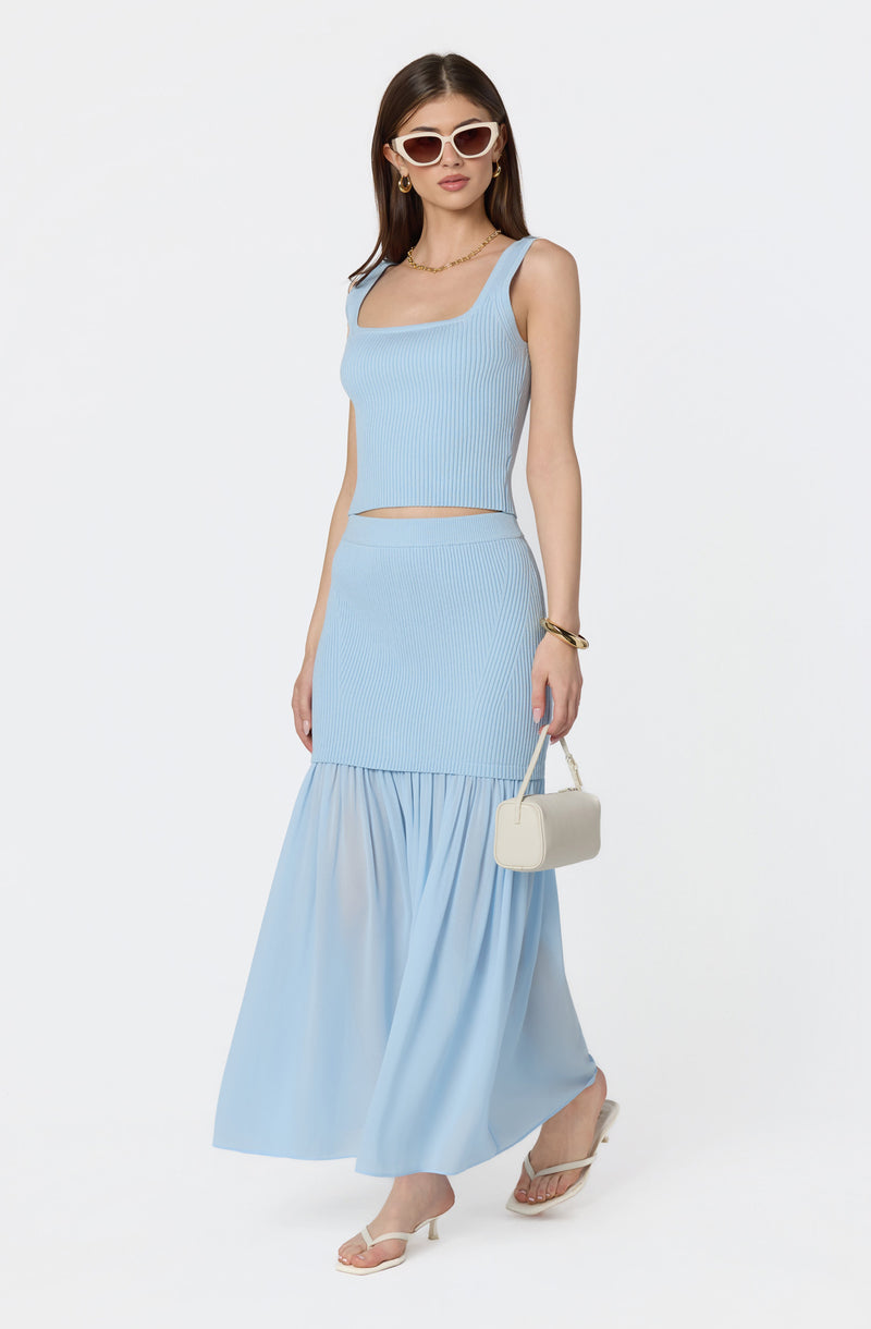 Light blue sleeveless knit crop top and matching high-waisted, tiered maxi skirt with ruffle at the hem.