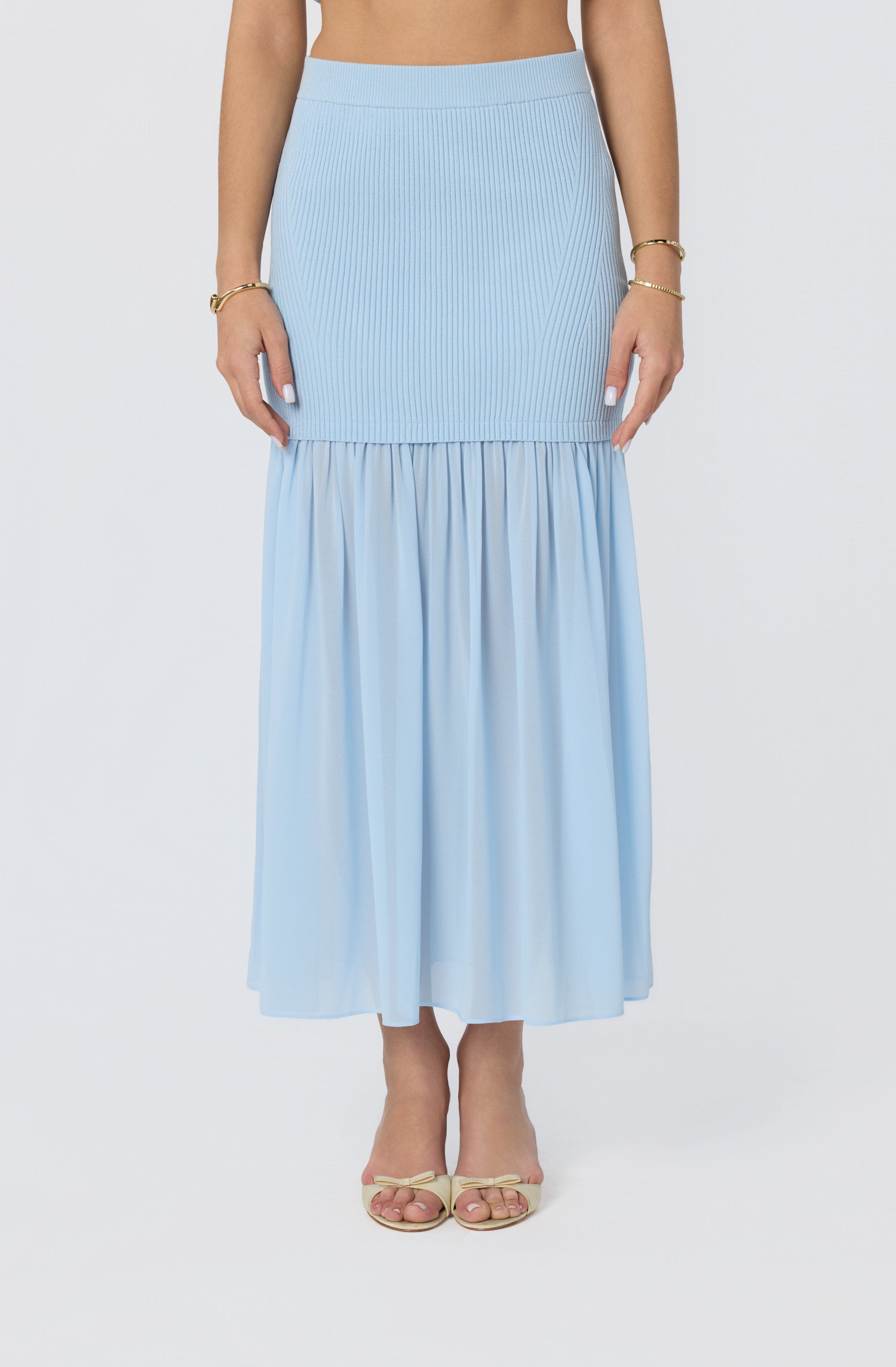 Light blue ribbed and pleated midi skirt with a tiered, flowing hem.