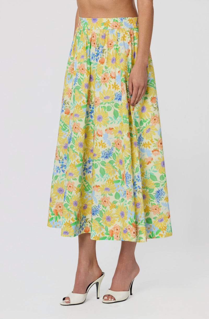 Long floral skirt with yellow, orange, purple, blue, and green patterns, high waist.