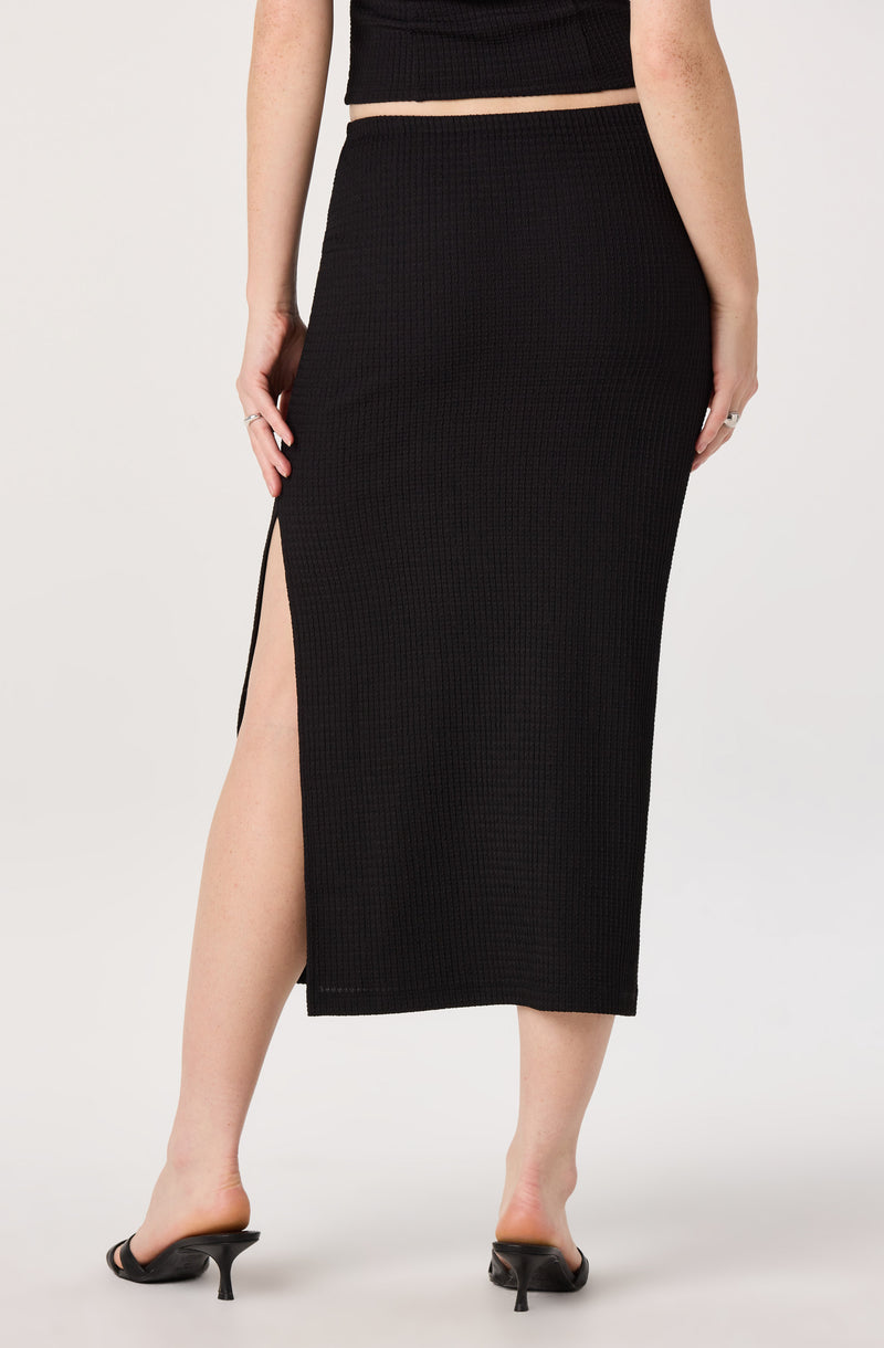 Black knitted midi skirt with a high slit on the left side.