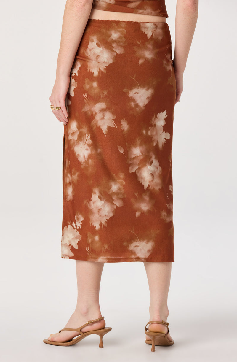 Brown tie-dye midi skirt with white floral pattern, paired with tan heels.