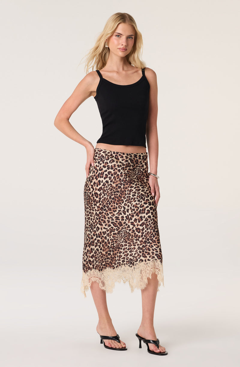 Woman wearing a black tank top and a leopard print skirt with lace hem.