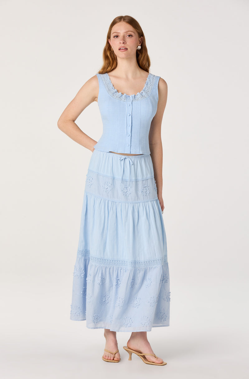 Light blue sleeveless crop top with lace details and a matching long skirt with embroidery.