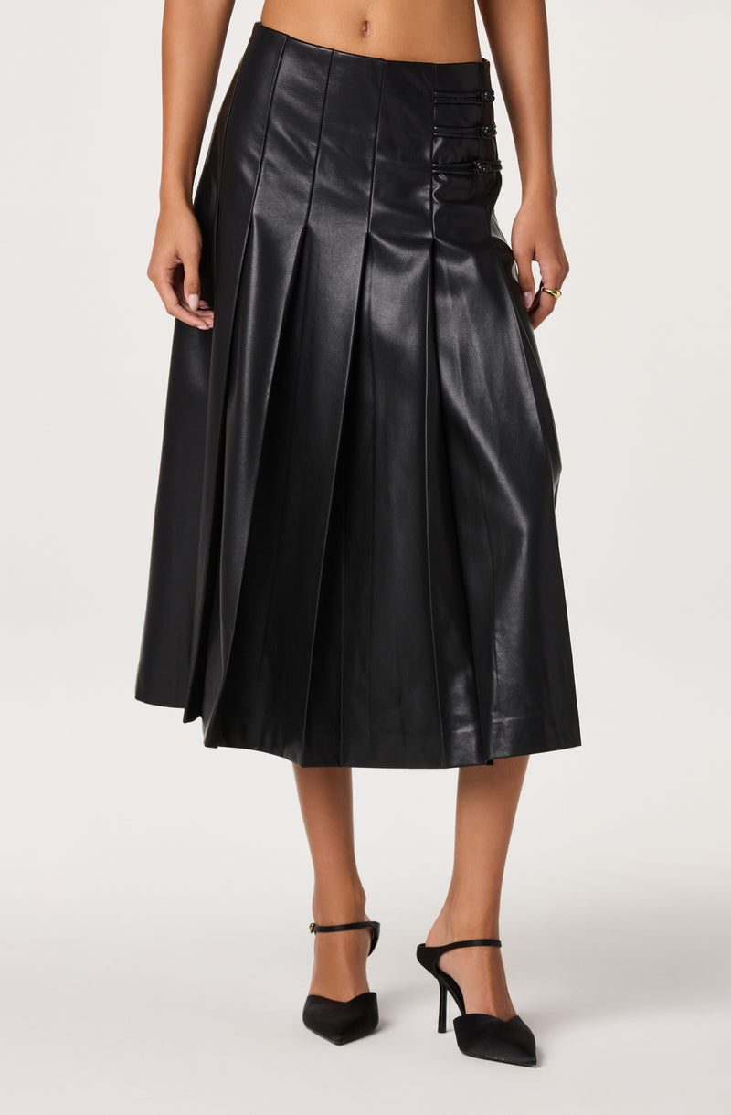 Black leather midi skirt with pleats and side buckle details, paired with black heels.
