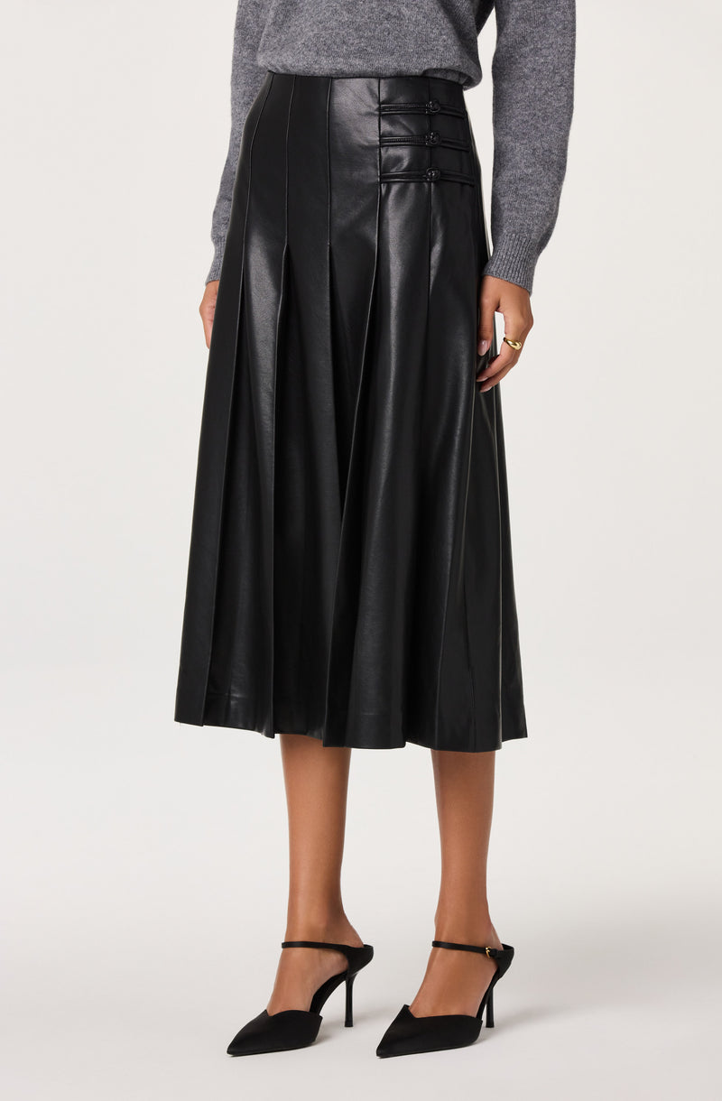 Black leather midi skirt with pleats and button details, paired with black heels.