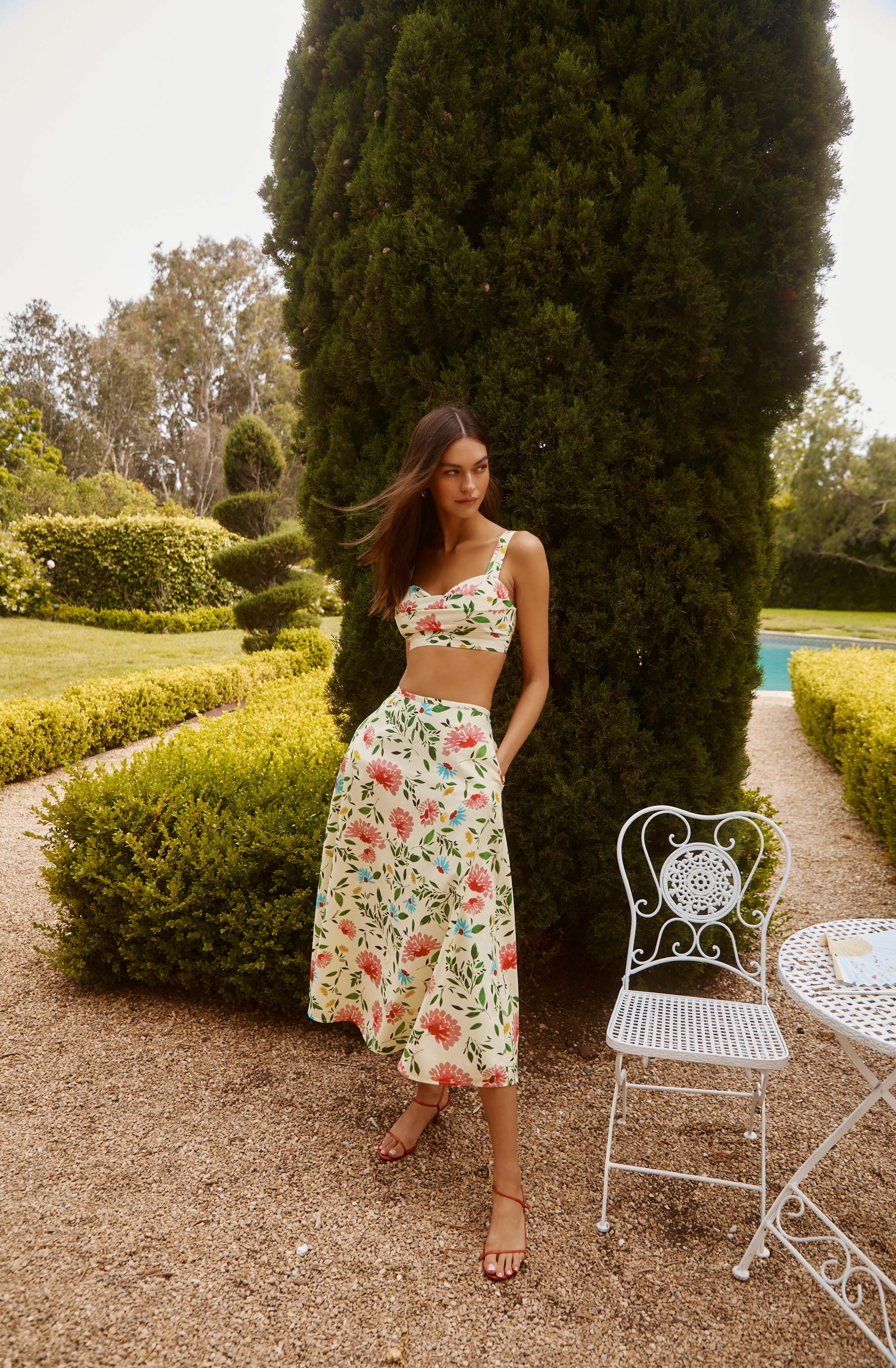 Woman wearing a floral crop top and matching wide-leg pants outdoors.