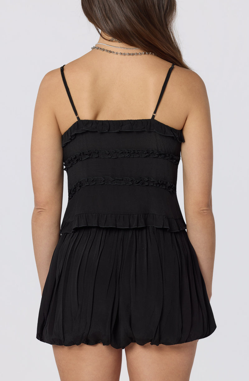 Black sleeveless romper with spaghetti straps and ruffled details.