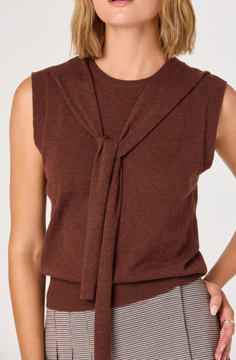 A sleeveless, knit sweater vest in a warm brown color featuring a decorative tied detail at the front. The vest has a round neckline and a ribbed hem at the waist.