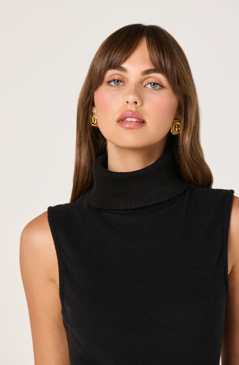 A woman is wearing a sleeveless black turtleneck sweater.