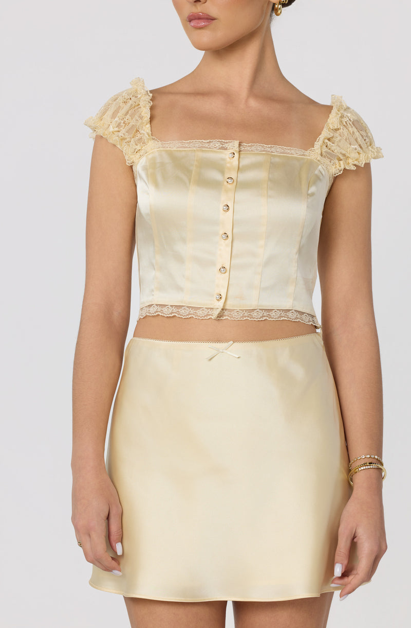 Cream satin bustier top with lace cap sleeves and lace trim, matching satin skirt.