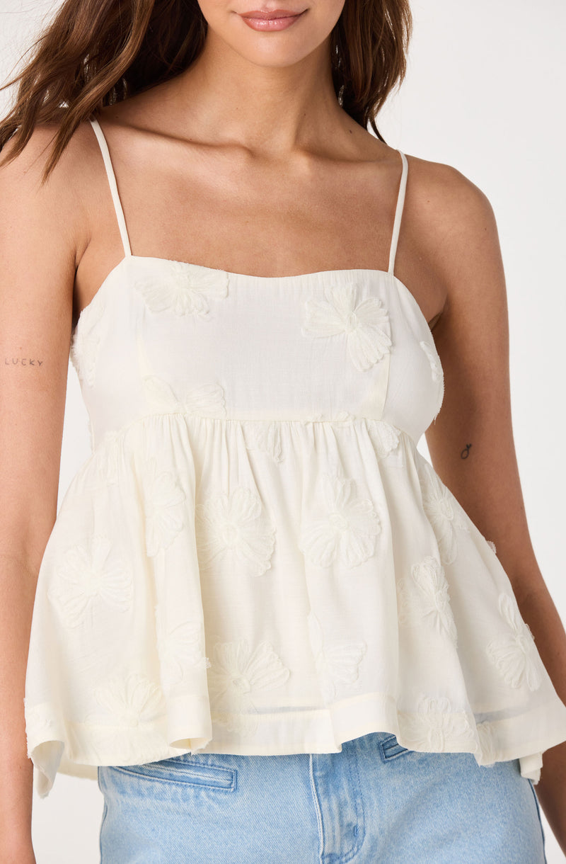 White sleeveless top with spaghetti straps and embroidered butterfly patterns.