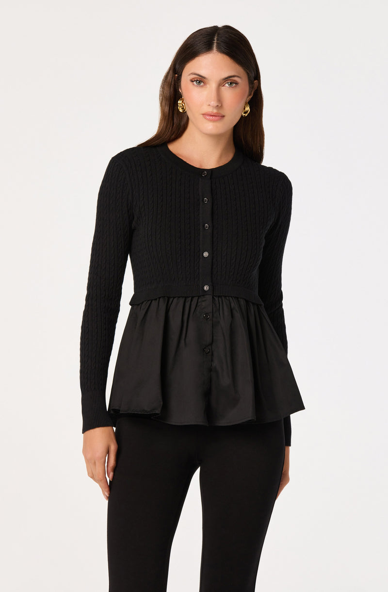 Black long-sleeve knit top with a peplum satin hem, paired with black pants.