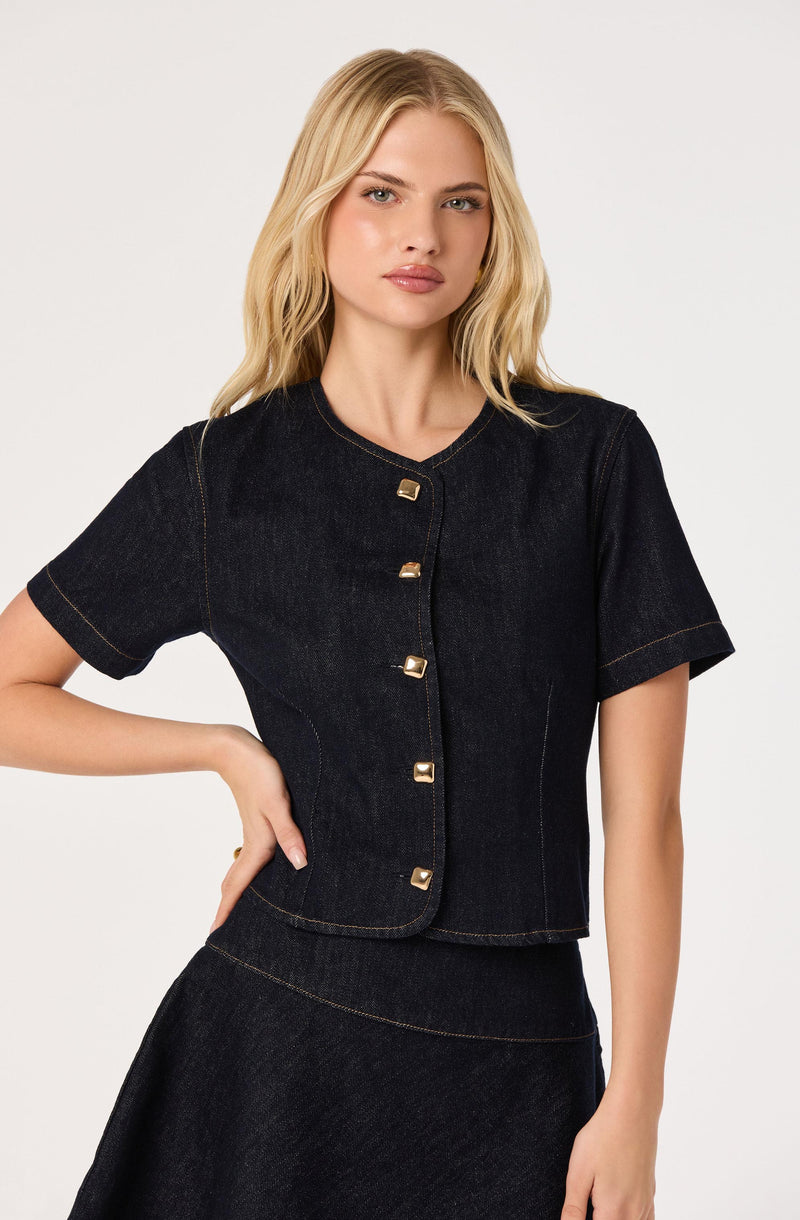 Black short-sleeve denim top with gold square buttons, paired with a matching black denim skirt.