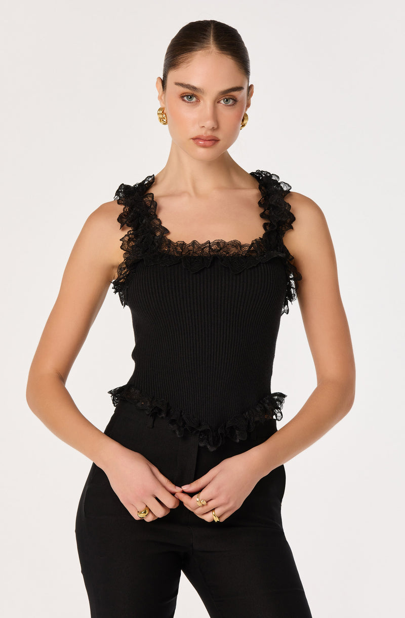 Black sleeveless top with ruffled lace trim around neckline and hem.