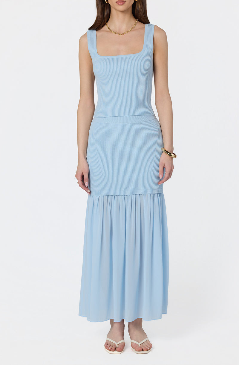 Light blue sleeveless ribbed knit dress with a fitted upper and a ruffled, gathered hem at the bottom.