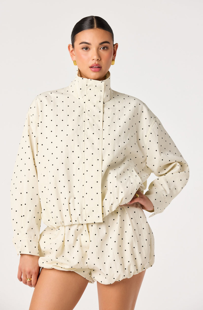 Cream-colored jacket and shorts set with black polka dots.