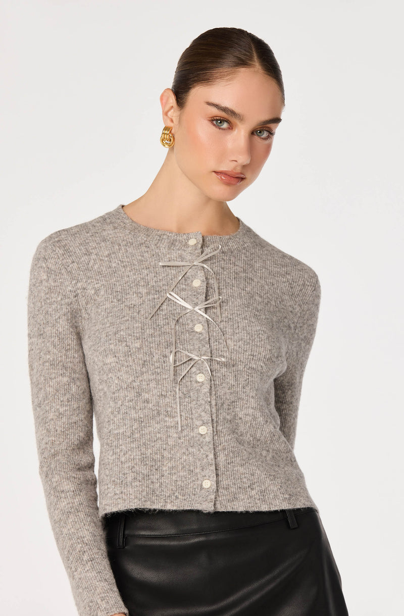 Light gray knit cardigan with bow-tie detail at front and gold buttons.