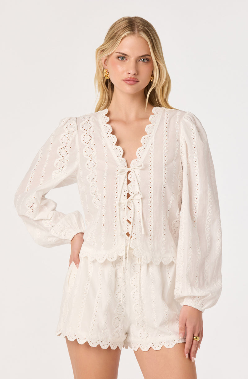 White eyelet lace blouse with ruffled front and scalloped edges, paired with matching shorts.