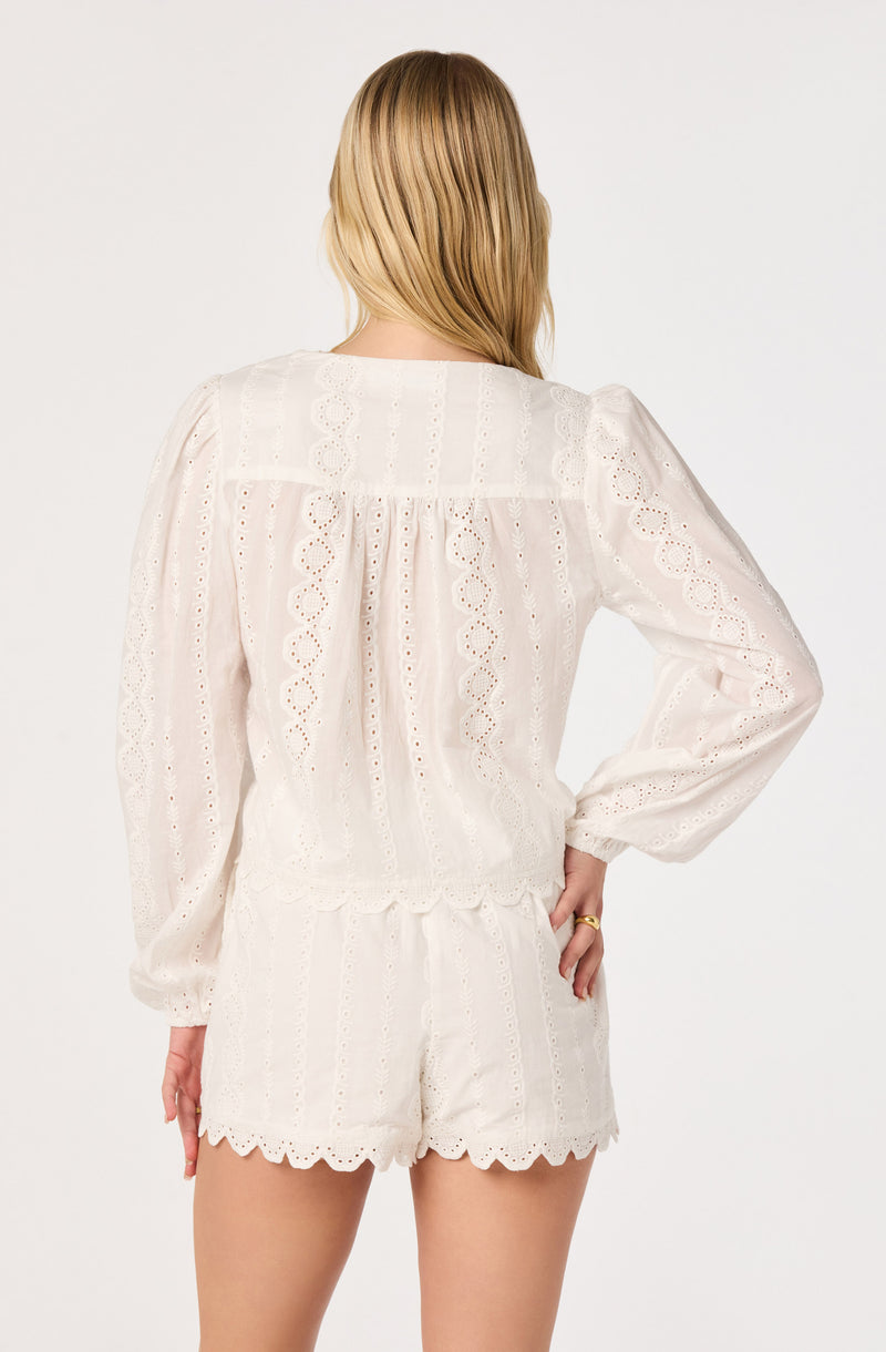 White eyelet embroidered long-sleeve top and matching white eyelet shorts.