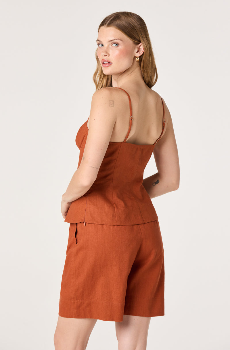 Woman in rust-colored camisole top and matching shorts.