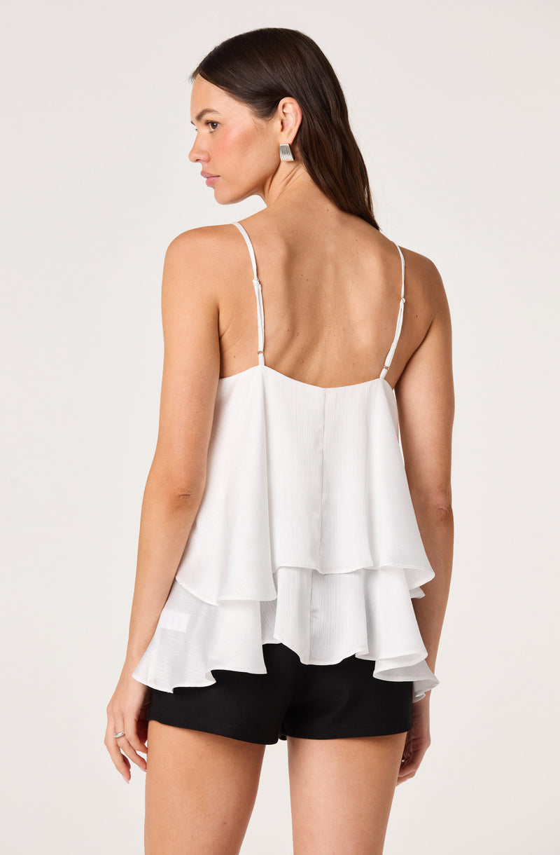 White sleeveless top with layered, ruffled fabric and thin spaghetti straps.