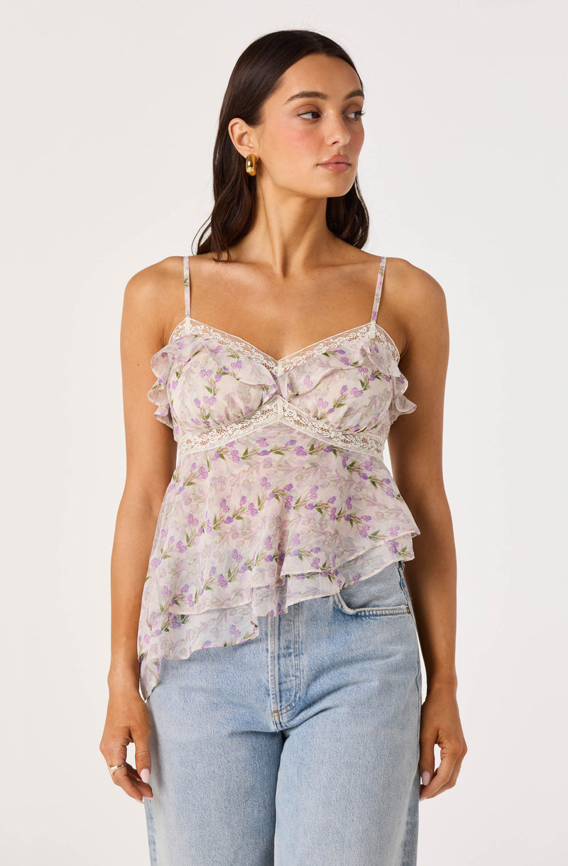 Woman wearing a light, floral, ruffled camisole with thin straps.