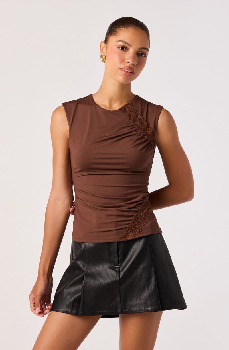 Brown sleeveless top with lace detail paired with a black leather mini skirt.