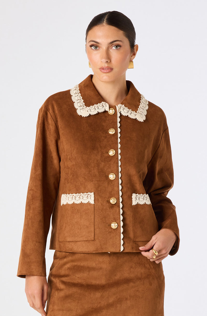 Woman in brown jacket with cream lace trim on collar, pockets, and button placket.
