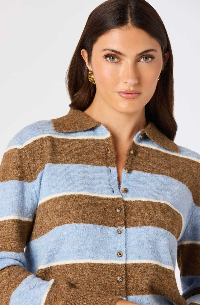 Woman wearing a brown and light blue striped button-up sweater with a collar.