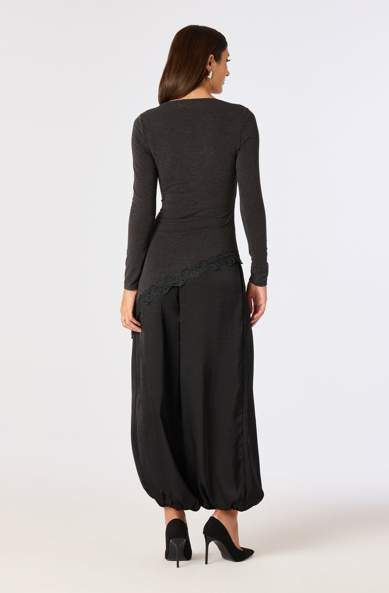 Woman in a dark gray long-sleeve top and black wide-leg pants with elasticized ankles, wearing black high heels.