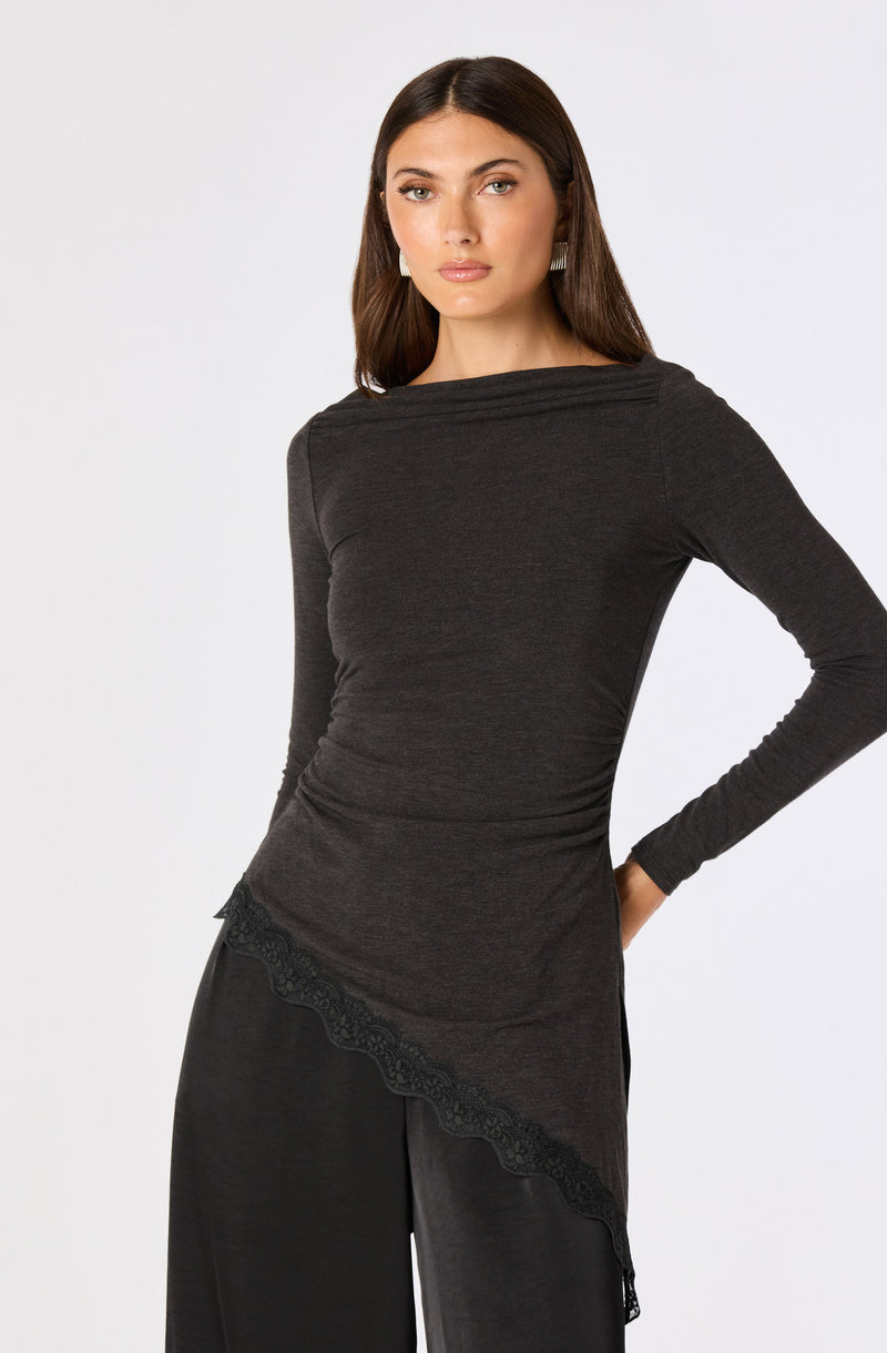 Woman wearing a dark gray long-sleeve top with lace details and matching wide-leg pants.