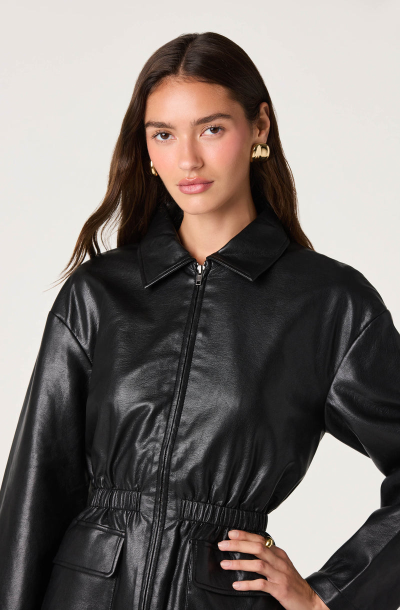 Woman in black faux leather zip-up jacket with a collar, long sleeves, and elastic waistband.