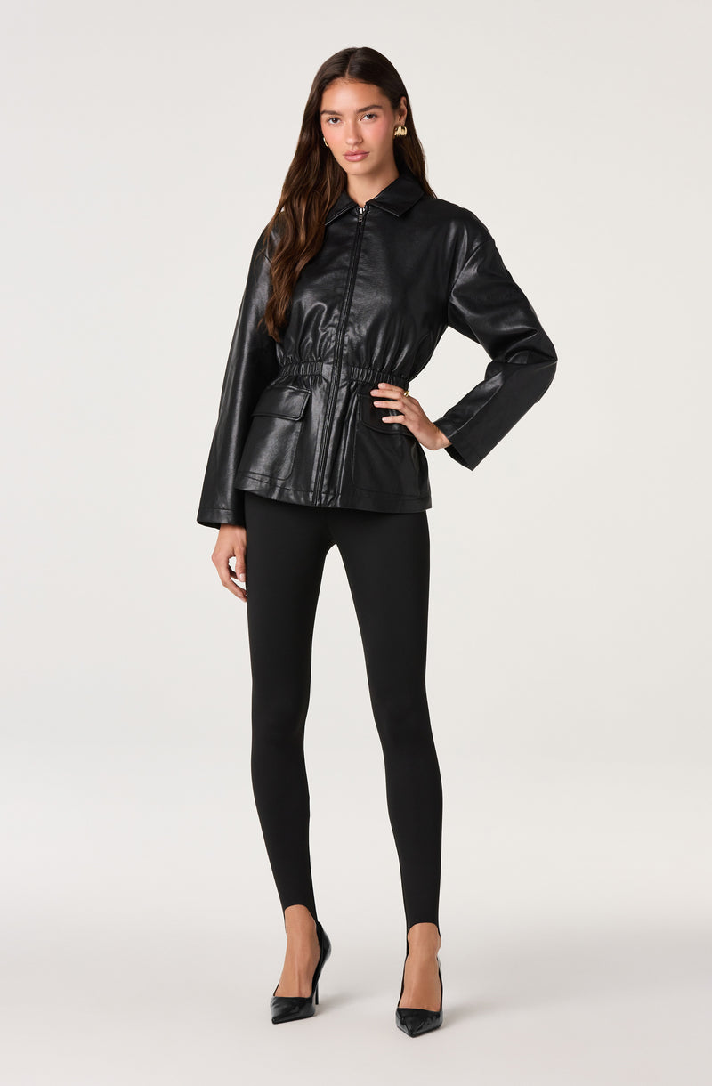 Woman wearing a black leather jacket, black leggings, and black high heels.