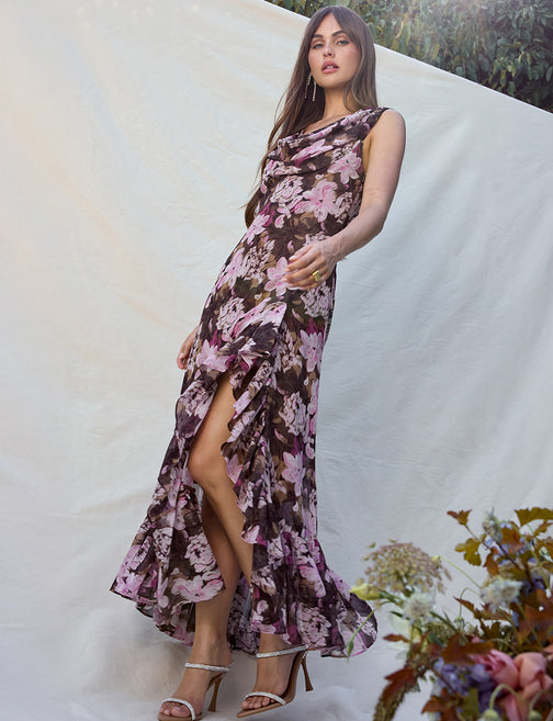Woman wearing a floral dress with a white background and flowers in the foreground