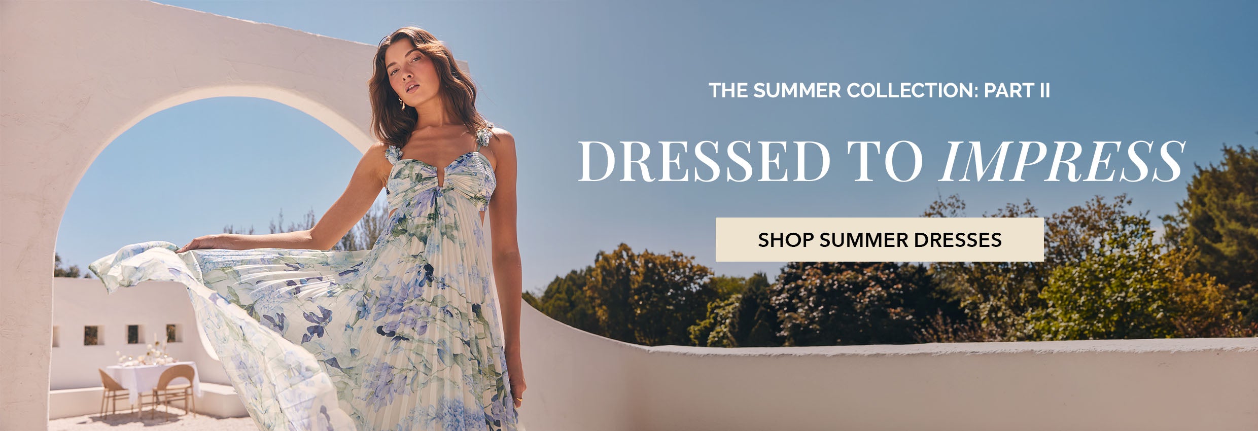 Woman in a flowy, sleeveless summer dress with a floral pattern.